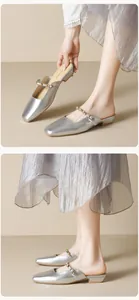 Detailed view of silver square-toe mule slippers with rhinestone strap and flat heel