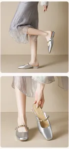 Detail view of silver square-toe Mary Jane mule shoes with metallic stud decoration