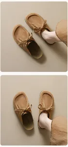 Makro-Detail von hellbraunen Wildleder-Mules mit Schnürschleife und runder Kappe