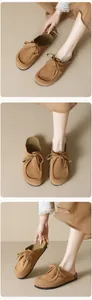Details von braunen Wildleder-Mules im Birken-Stil mit Schleife und Kork-Plateausohle