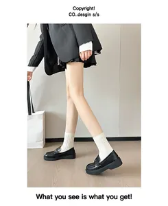 Classic black leather platform loafers styled with white socks and a pleated skirt outfit