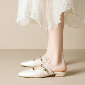 Elegant beige pointed-toe mules with gold-studded strap and low square heels