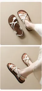 Detailansicht der weißen Riemchen und Zehenschlaufe an minimalistischen Sandalen