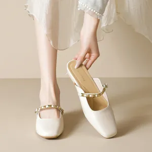 Beige closed-toe mule shoes with gold stud strap and elegant square-toe design