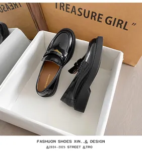Top-down view of black patent leather loafers with thick soles and glossy finish details