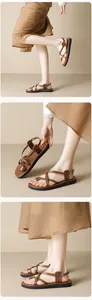 Detail von braunen Kunstleder-Riemchensandalen mit verstellbaren Metallschnallen und weichen Sohlen