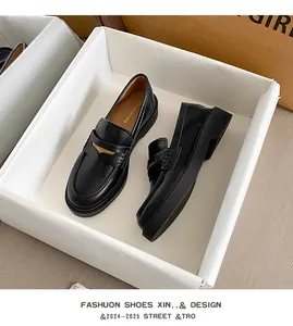 Detail view of black patent leather loafers with gold buckles and chic platform soles