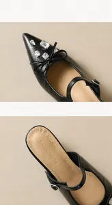 Details von spitzen schwarzen flachen Schuhen mit Kristallverzierung und Schleife