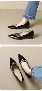 Detail von schwarzen spitzen flachen Schuhen mit funkelnden Kristallen auf Lackleder