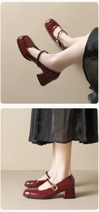 Detail showing deep red patent leather square toe Mary Jane pumps with block heels