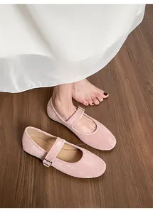 Détails des ballerines Mary Jane en daim rose avec boucles sur un sol en bois chic