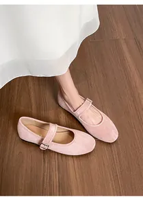 Détail de ballerines Mary Jane en daim rose avec bride sur un sol en bois