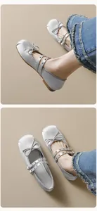 Detail of silver satin Mary Jane ballet flats with bow and double straps on denim