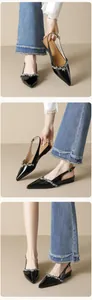 Λεπτομέρεια από μαύρα λουστρίνι slingback παπούτσια με λουράκι από στρας και μυτερή μύτη