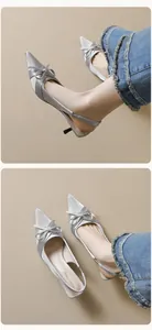 Detailed view of silver satin pointed-toe slingback heels with elegant bow detail