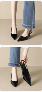 Macro detail of black pointed-toe slingback kitten heels with smooth leather finish