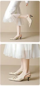 Detail of elegant pointed-toe slingback heels with a decorative bow and kitten heels