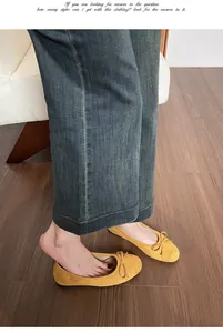 Detailopname van gele suède ballerina's met strik en styling met een denim jeans