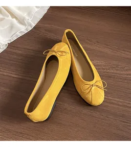 Détail de ballerines en daim jaune avec un nœud délicat et un bout rond au style élégant