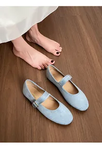 Gros plan sur les ballerines Mary Jane en daim bleu clair avec brides sur parquet