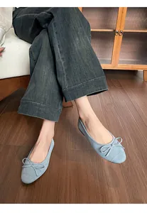 Detail van lichtblauwe zachte ballerina's met strik en fijne witte stiksels
