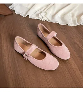 Vue de dessus de ballerines Mary Jane en daim rose avec bride sur un sol en bois sombre