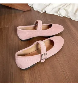Ballerines Mary Jane en daim rose avec bout rond et bride à boucle sur sol en bois