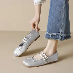 Silver satin Mary Jane flats with bow detail and double straps on model with jeans