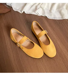 Vue de dessus de ballerines Mary Jane jaunes en daim sur parquet avec tissu blanc élégant