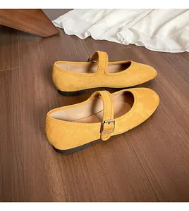 Vue de dessus de ballerines Mary Jane en daim jaune avec boucle sur fond de bois sombre