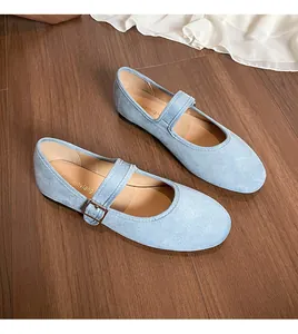 Détail de chaussures babies plates en daim bleu clair avec boucle argentée élégante