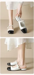Detail of French style Mary Jane mules featuring classic bicolor design and pearl straps