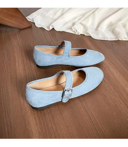 Vue de dessus de ballerines Mary Jane en daim bleu clair avec boucle argentée sur bois