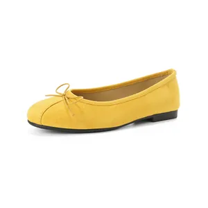 Ballerines classiques en daim jaune avec bout rond et nœud sur fond blanc éclatant