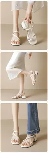 Detail view of beige block heel sandals with delicate cross straps and silver buckle finish