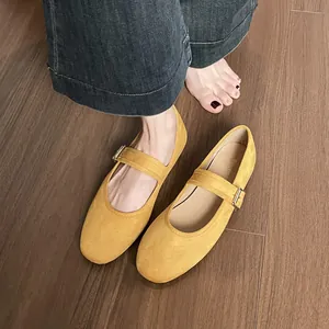 Ballerines Mary Jane en daim jaune à bout rond avec bride sur parquet en bois sombre