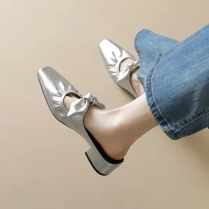 Silberne Metallic-Mules mit quadratischer Zehenpartie und Schleifendetail zu Jeans