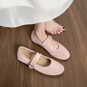 Ballerines Mary Jane en daim rose avec bride ajustable sur parquet rustique
