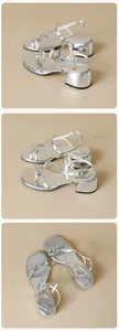 Macro detail of silver metallic strappy sandals featuring buckle and low block heel