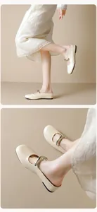 Close-up of cream Mary Jane flat shoes featuring a stylish silver metallic buckle strap