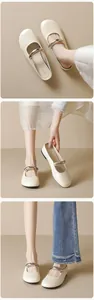 Detail of cream Mary Jane flats featuring a metallic silver bar and smooth leather texture