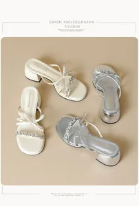 Detailed view of women's block heel sandals featuring bows and rhinestone straps