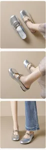 Detailed view of silver Mary Jane mules with metallic texture and buckle detail