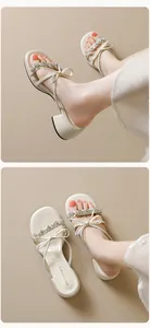 Detail of beige block heel sandals featuring sparkling rhinestone bow and crisscross straps