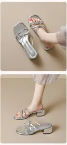 Detail of silver block heel sandals featuring a rhinestone strap and elegant bow design