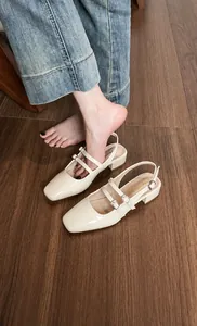 Gros plan sur sandales Mary Jane en cuir verni beige crème avec double bride et bout carré
