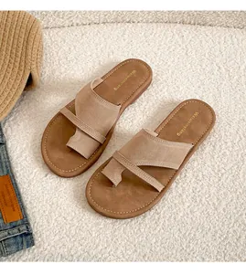 Close-up of beige leather thong sandals with cross-strap design and contrast stitching details
