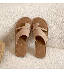 Close-up of leather thong sandals with suede straps and detailed white stitching