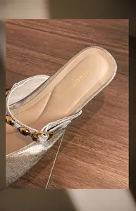 Macro view of silver square toe mule showing padded latex insole and metal buckle detail