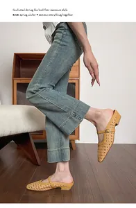 Close-up of yellow woven pointed-toe mules paired with wide-leg blue denim jeans